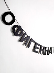 Black letters hang on a rope and form the word "Awesome" on a white background