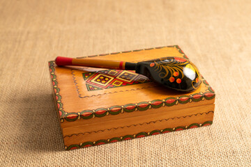 One old wooden box with a wooden spoon on jute cloth, close-up.