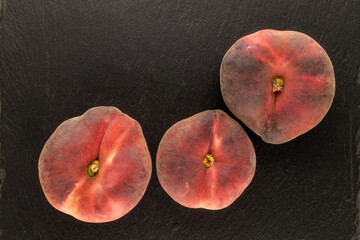 Sweet fig peaches on slate stone, top view, macro.