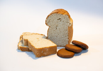 Pan de molde casero con miga suave, acompañado de tradicionales pancitos de miel del norte argentino, sobre fondo blanco. Representación de la panadería artesanal y la cultura culinaria de Jujuy