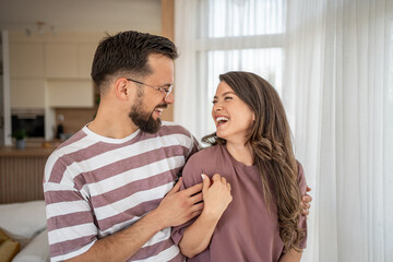 Happy couple laughing and embracing at home