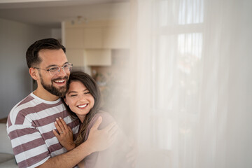 Obraz premium Happy couple embracing tenderly in their modern home