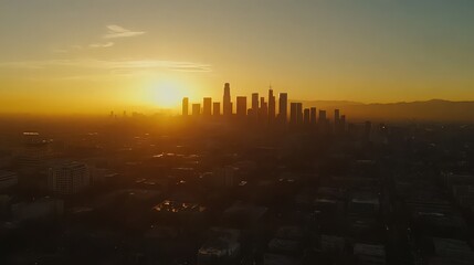 Fototapeta premium City skyline silhouette against a vibrant sunset with golden light illuminating the urban landscape