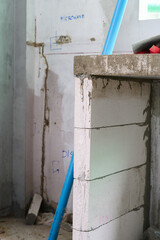 Concrete wall during house renovation. Building new interior structure with lightweight brick and cement shows progress of construction inside messy unfinished room