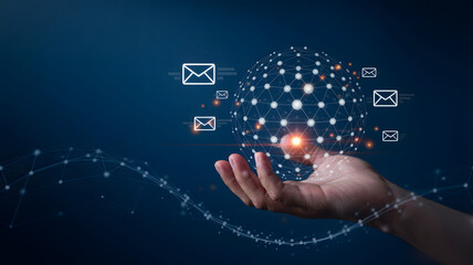 Unlock global communication with hand holding glowing sphere and floating email icons on blue background