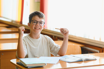 Enthusiastic elementary school student celebrating success in classroom