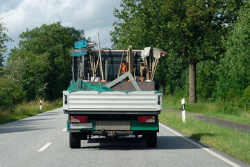 Small truck loaded with garden tools on country road