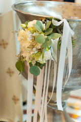 Beautiful floral arrangement with silky ribbons adorning a silver basin at an intimate celebration