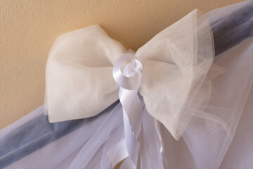 Elegant white ribbon bow adorning a delicate veil at a festive celebration