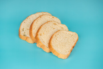 Neatly sliced white bread loaf arranged on a vivid blue background, showcasing soft texture and golden crust.