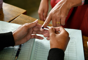 An Indian voter gets inked after casting her vote during the general elections, symbolizing...