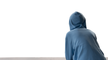 Rear view of a person in a blue hoodie looking towards a stark white background conveying solitude contemplation or anonymity. Ample copy space for design.