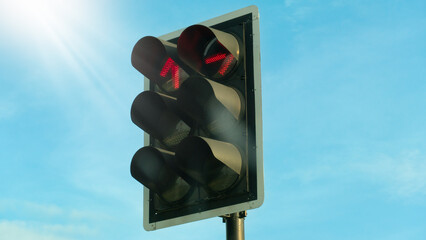 Angled view of red traffic light digital. Urban stop signal on street. Types that prohibit going straight and turning right. Safety and caution symbol. Light shines from above.