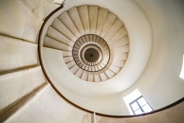 Interior shot of a spiraling circular staircase with stone steps in the old church of St Nicholas