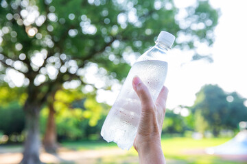 手にペットボトルの冷たい水　ミネラルウォーター　暑い夏