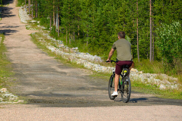 Man with Bicycle on Road Near Green Park in Summer