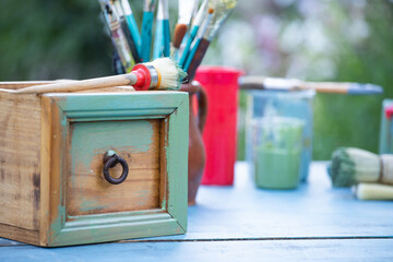 Painting a wooden furniture outdoors, an eco-friendly re-use business.