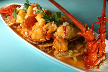 Australian Lobster with Savory Sauce on a Bed of Crispy Noodles in long dish side view of Chinese cuisine