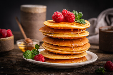 Healthy summer breakfast, homemade classic american pancakes with fresh berries and honey. High quality photo