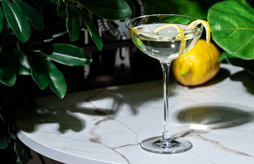 Dukes martini cocktail made with gin and dry vermouth on a marble table, enhanced by lemon peel