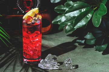 Vibrant red cocktail offers a blend of tequila and ginger beer, presented with ice and a lemon...