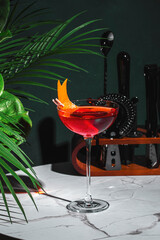 Red alcoholic cocktail drink with bitters, juice, prosecco sparkling wine and orange zest