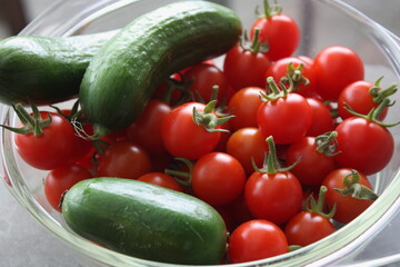 Frische Cherrytomaten und Snackgurken, Salamanda F1, in einer Glasschale.