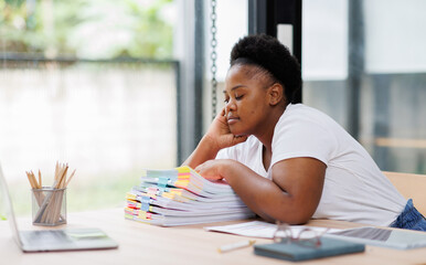 Tired burned out or sad,stress,boredom, African American woman with Afro hair on desk, exhausted by red tape paperwork piles, feeling stuck in this goddamn office. Burnout concept.