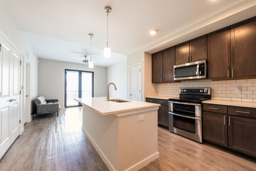 Empty kitchen and living room open plan modern apartment with large big island microwave oven and window balcony by sofa couch in luxury house home