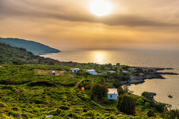 Sunset evening landscape on Agia Kyriaki thermal hot springs village on Ikaria island, Greece fishing village of Almyrida, Greek longevity blue zone