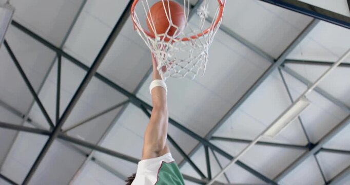 Glitch clearing sports gym, player gripping ball jumping, dunking through clear backboard to score