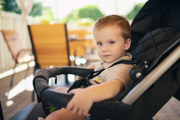 Little boy waiting his order sitting in outdoor cafe