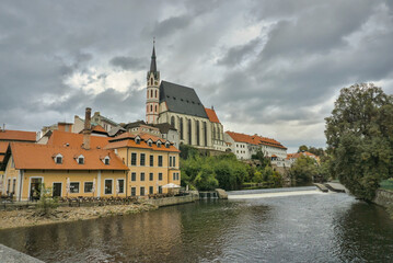 Naklejka premium ký Krumlov, Czech Republic: St. Vitus Church dominates the skyline above the Vltava River.