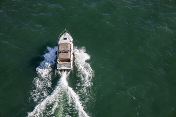 A small boat navigating the St. Lawrence River on a clear day, surrounded by calm water and open...