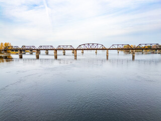 Obraz premium Drone photo showing a bridge connecting two urban areas in Montreal, capturing cityscape, infrastructure, and the surrounding environment from above.