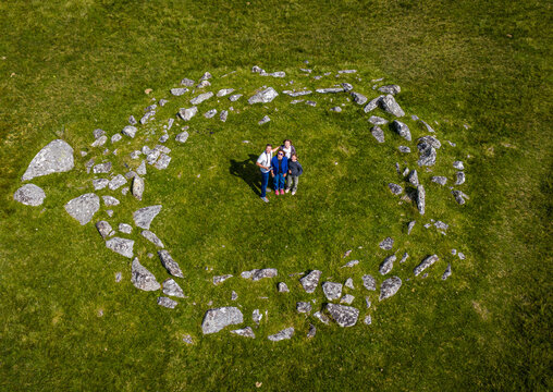 Family at Bronze Age stone rows and settlement remains at Merrivale, Dartmoor, surrounded by grassy moorland and footpaths