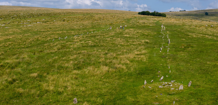 Aerial view of Bronze Age stone rows and settlement remains at Merrivale, Dartmoor, surrounded by grassy moorland and footpaths