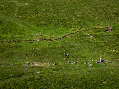 Aerial view of Bronze Age stone rows and settlement remains at Merrivale, Dartmoor, surrounded by grassy moorland and footpaths