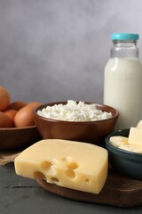 Different dairy products and eggs on grey wooden table, closeup