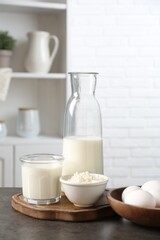 Different dairy products and eggs on gray textured table in kitchen