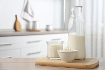 Dairy products. Fresh milk and cottage cheese on wooden table in kitchen. Space for text