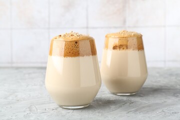Delicious dalgona coffee in glasses on grey table, closeup