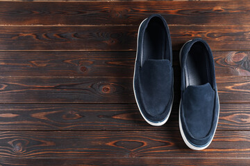 Pair of dark blue shoes on wooden surface, flat lay. Space for text