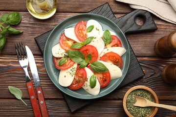Tasty salad Caprese served on wooden table, flat lay