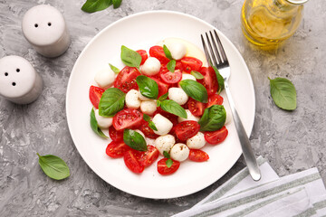 Tasty salad Caprese served on grey table, flat lay