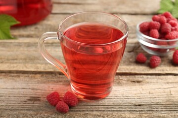 Tasty raspberry tea and berries on wooden table, closeup