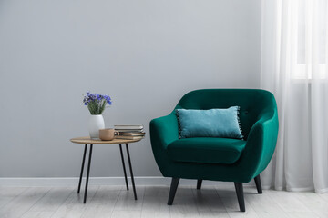 Comfortable armchair and decor near light gray wall indoors