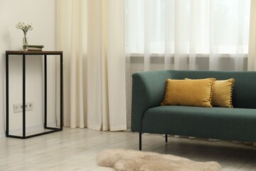 Stylish furniture near window with curtains in living room. Interior design