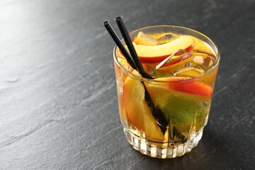 Refreshing iced peach tea in glass on grey table, closeup. Space for text