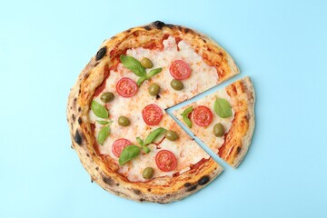 Delicious pizza with tomatoes, basil and olives on light blue background, top view